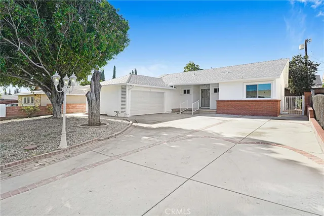 a view of a house with a yard and large tree