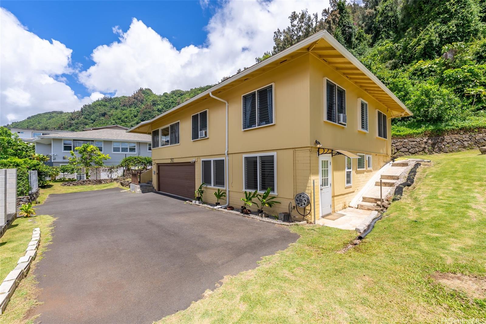 2811 Henry Street Honolulu, HI 96817 - Photo 2 of 25 Curb appeal abounds with crisp white trim against sunny yellow siding, complemented by a large driveway and a separate lower-level entrance.