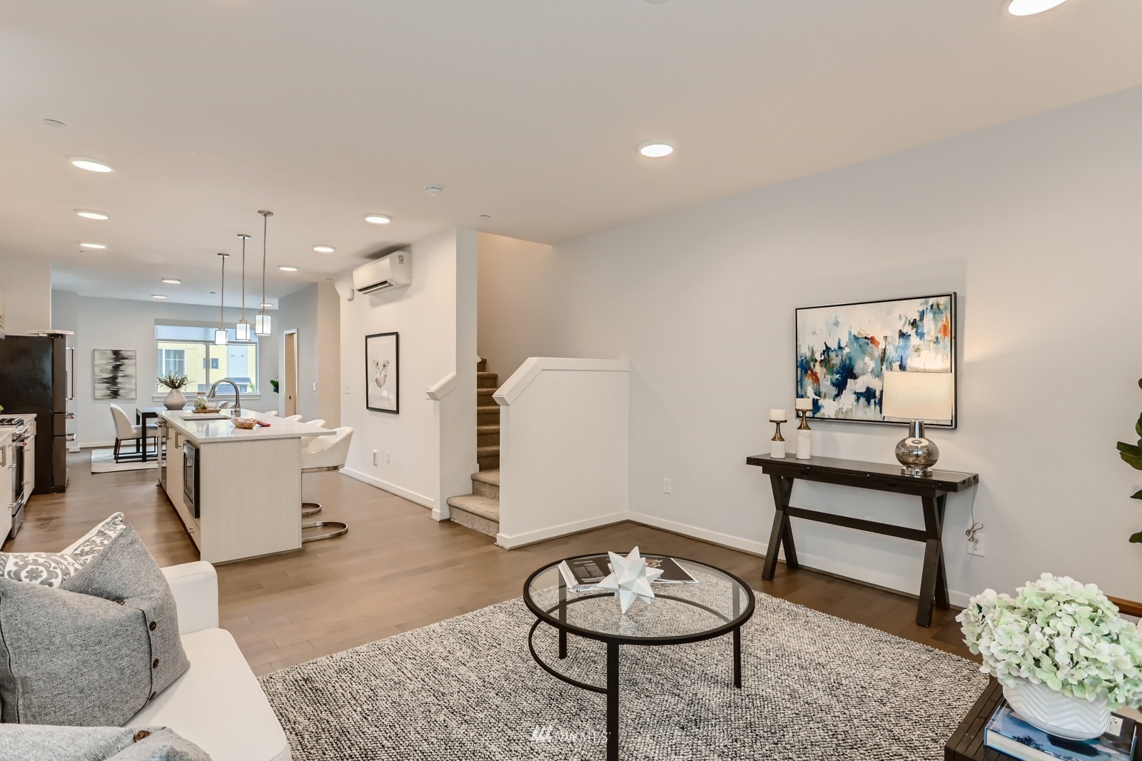 a living room with furniture and a wooden floor