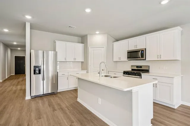 a kitchen with stainless steel appliances a refrigerator stove microwave and cabinets