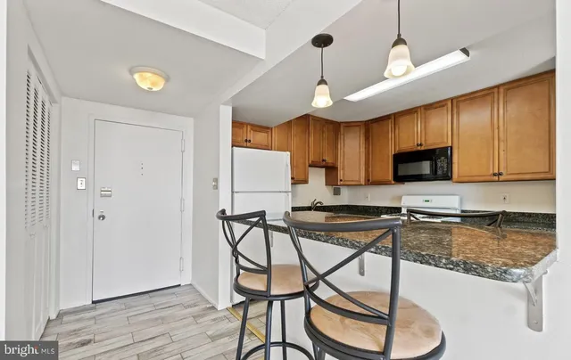 a kitchen with stainless steel appliances granite countertop a stove refrigerator and cabinets