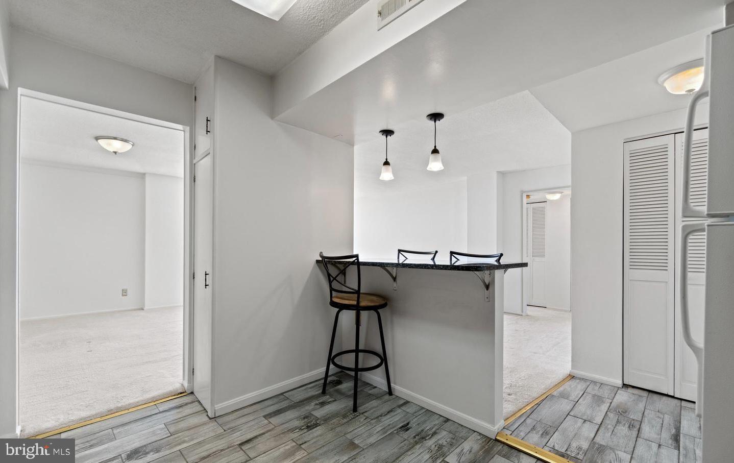 118 Monroe Street, Unit 1181109 Rockville, MD 20850 - Photo 13 of 41 a view of a kitchen with wooden floor and staircase