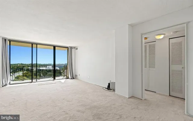 an empty room with sliding glass door and mountain view