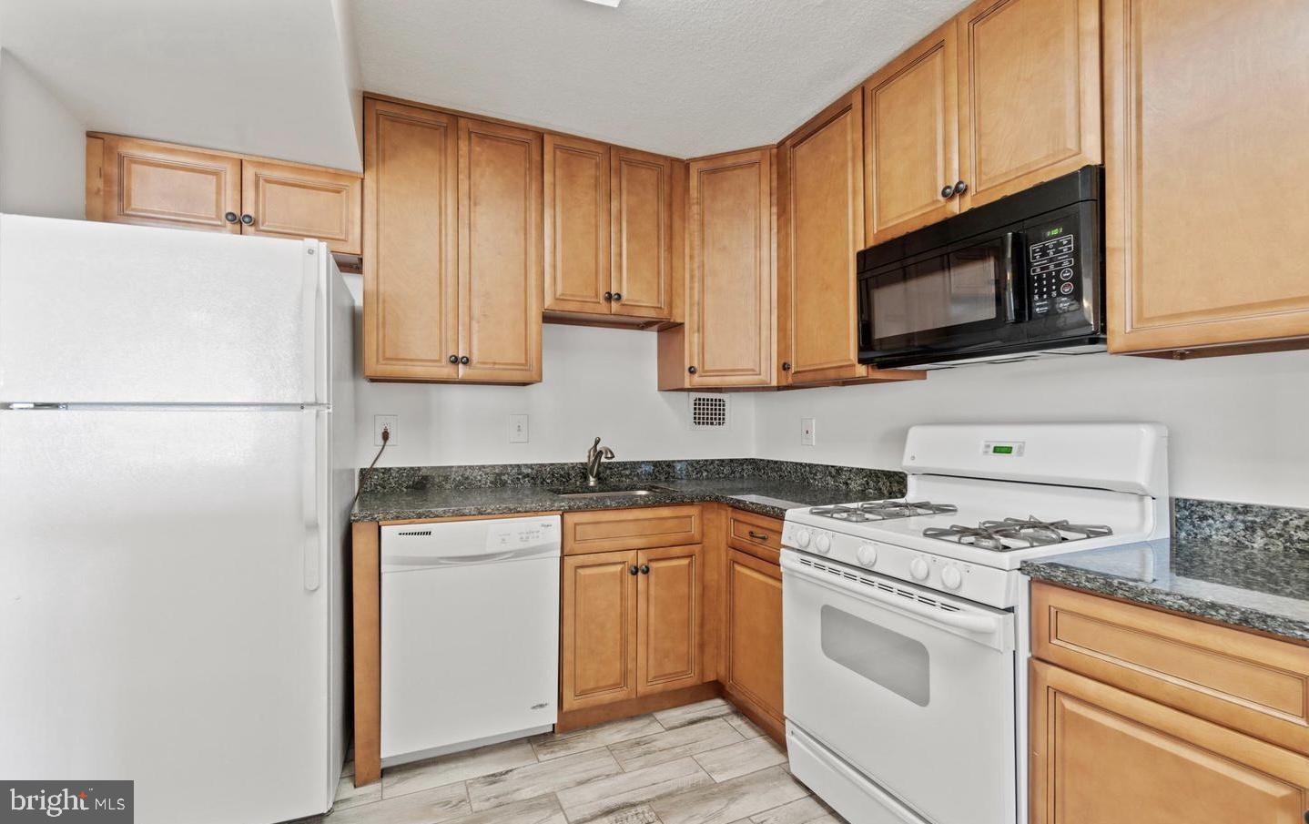 118 Monroe Street, Unit 1181109 Rockville, MD 20850 - Photo 9 of 41 a kitchen with granite countertop cabinets stainless steel appliances and sink