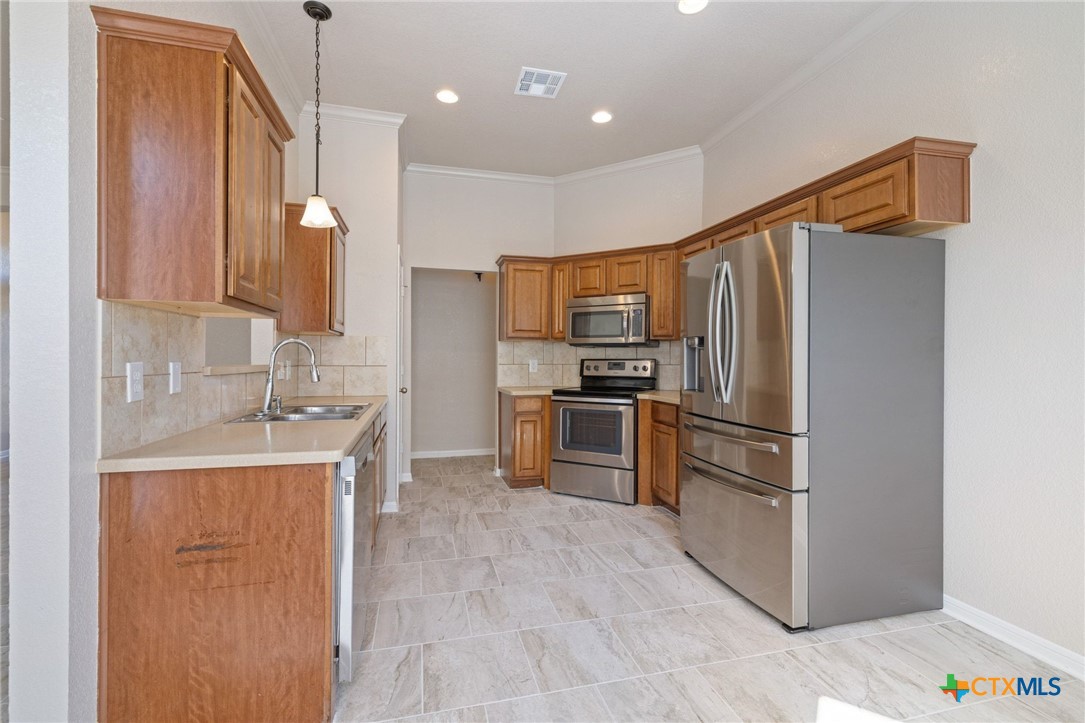 5607 Aberdeen Court Temple, TX 76502 - Photo 10 of 30 a kitchen with kitchen island a refrigerator sink and stove