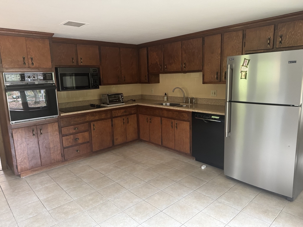 628 Stow Road Boxborough, MA 01719 - Photo 2 of 5 a kitchen with stainless steel appliances granite countertop a refrigerator stove a sink and dishwasher
