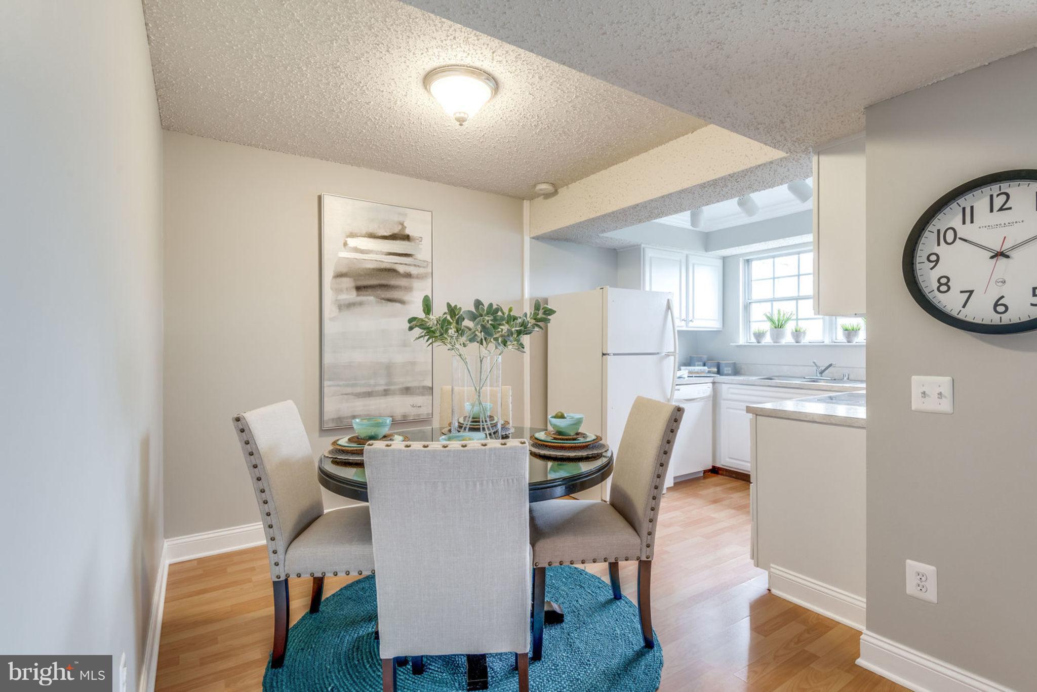 104 Fort Evans Road Southeast, Unit A Leesburg, VA 20175 - Photo 11 of 24 a dining room with furniture a large window and wooden floor