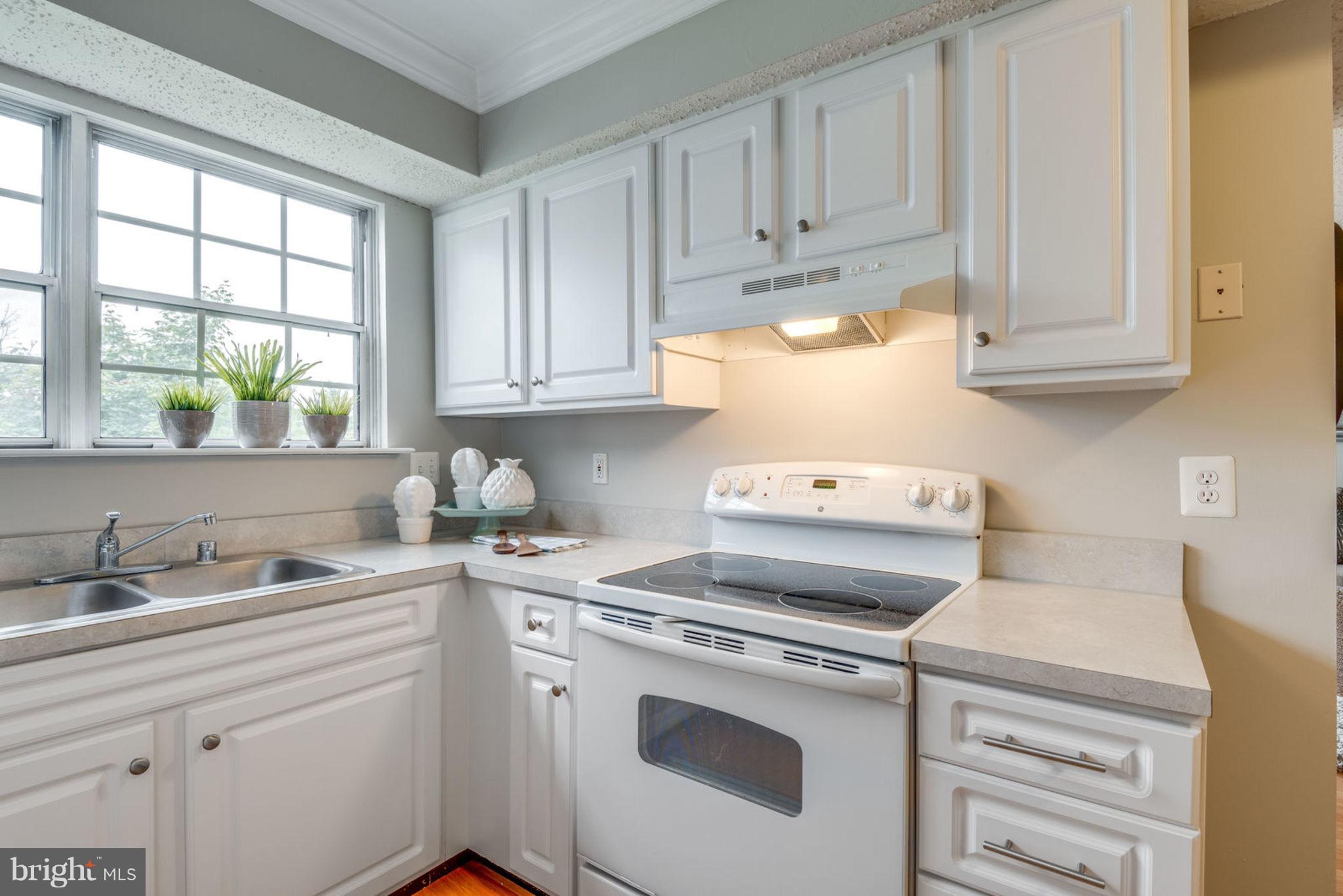104 Fort Evans Road Southeast, Unit A Leesburg, VA 20175 - Photo 13 of 24 a kitchen with white cabinets and white appliances