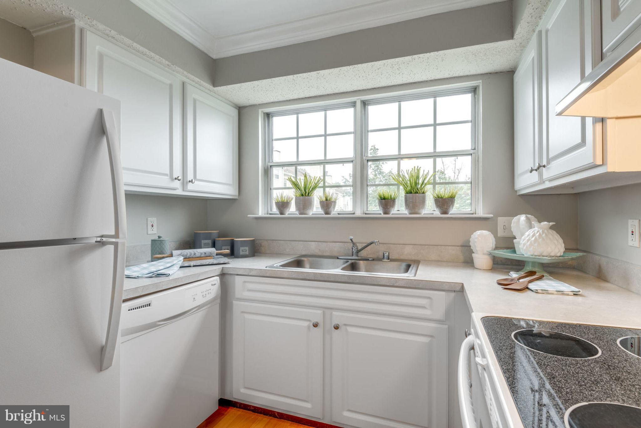 104 Fort Evans Road Southeast, Unit A Leesburg, VA 20175 - Photo 14 of 24 a kitchen with a sink a stove a refrigerator and cabinets