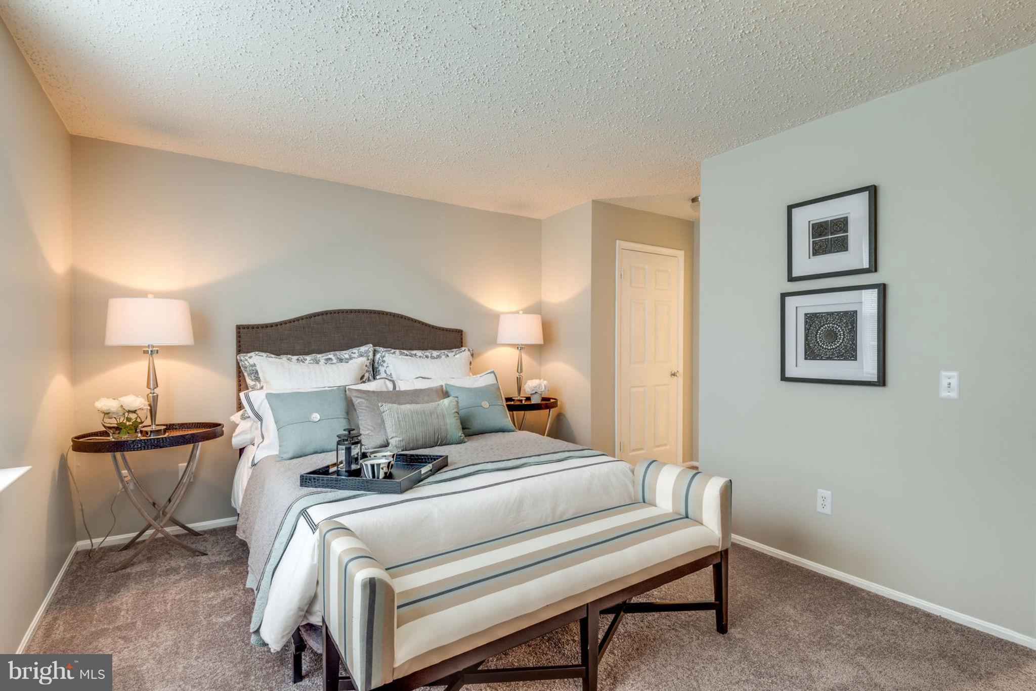 104 Fort Evans Road Southeast, Unit A Leesburg, VA 20175 - Photo 17 of 24 a bedroom with a bed and a lamp on table