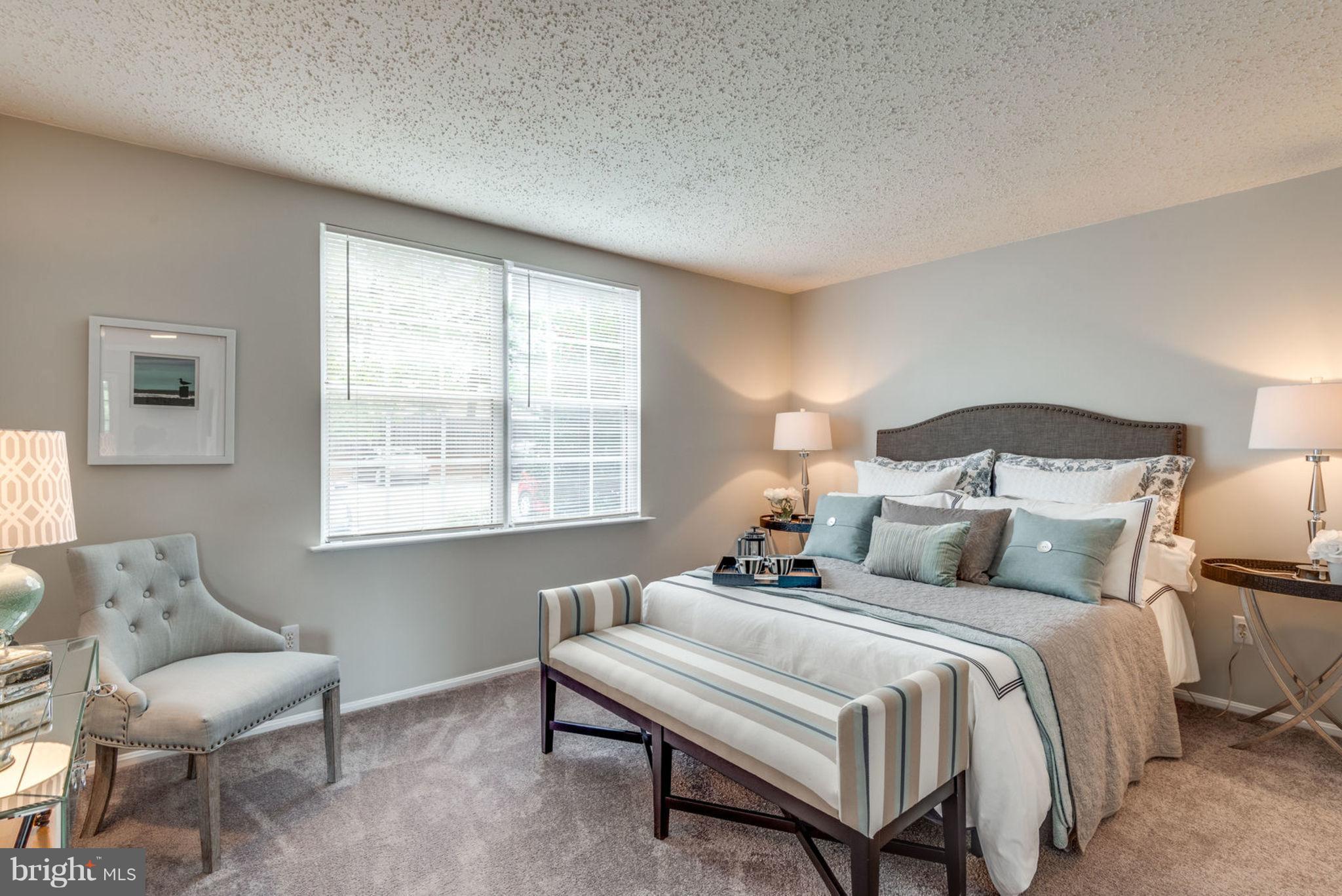 104 Fort Evans Road Southeast, Unit A Leesburg, VA 20175 - Photo 18 of 24 a bedroom with a bed and a chair