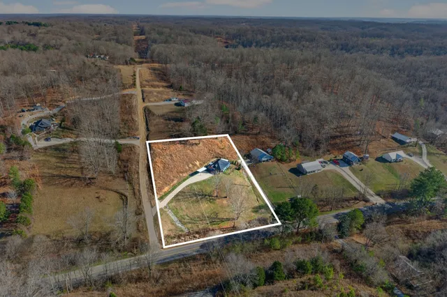 an aerial view of a house with a yard and mountain view