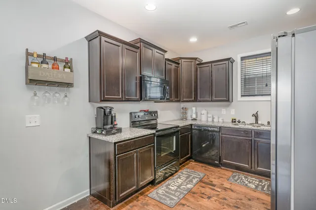 a kitchen with stainless steel appliances granite countertop a sink stove and cabinets