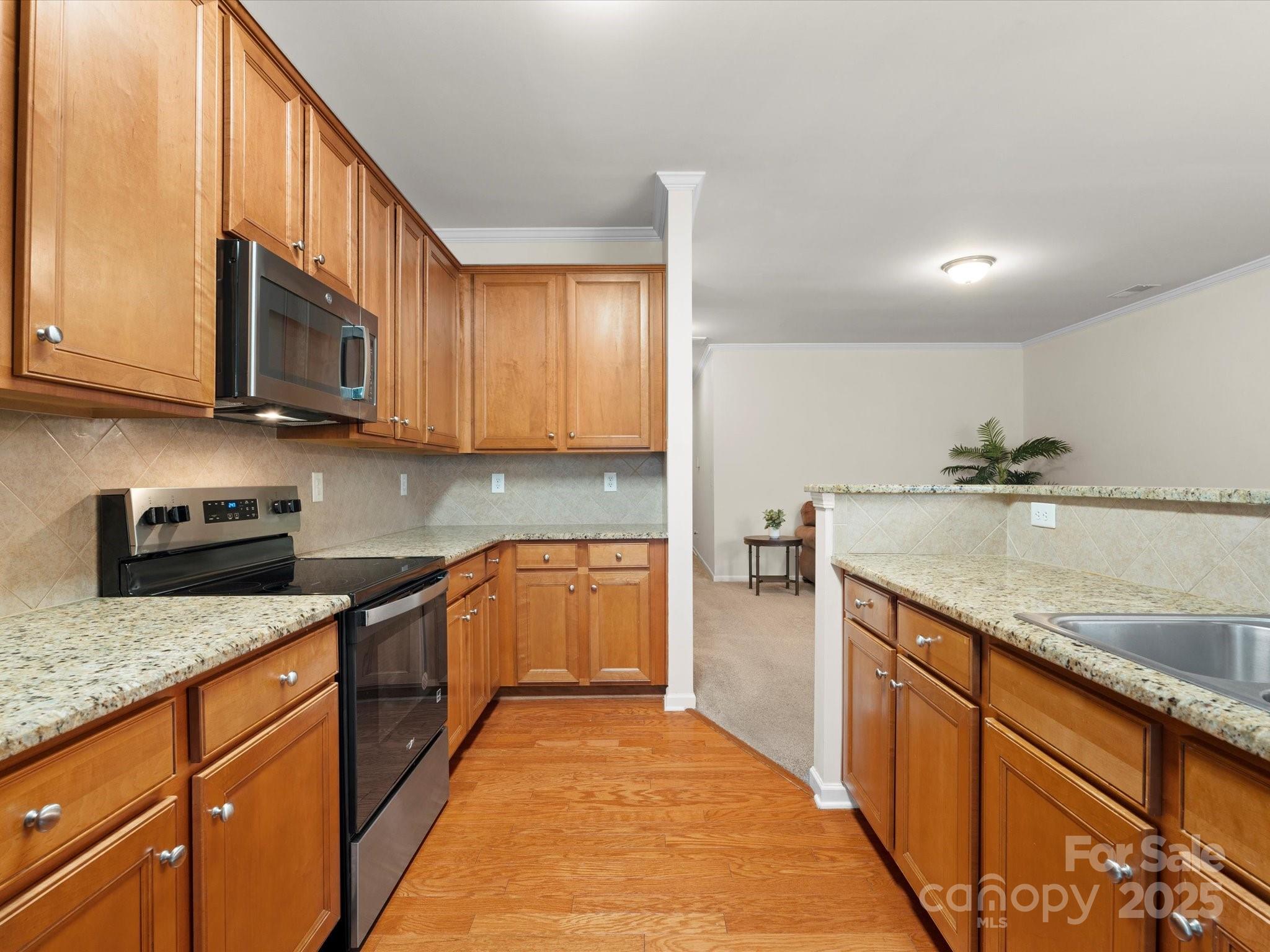 2137 Midnight Blue Lane Fort Mill, SC 29708 - Photo 9 of 40 a kitchen with stainless steel appliances granite countertop wooden cabinets a stove top oven a sink and dishwasher