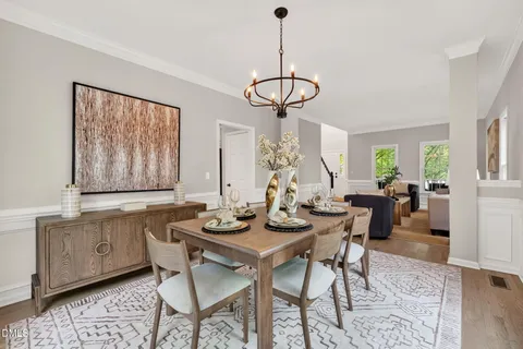 a dining room with wooden floor and a floor to ceiling window