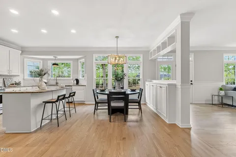 a kitchen with stainless steel appliances granite countertop white cabinets a window a sink and a microwave