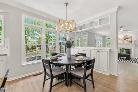 a kitchen with granite countertop white cabinets white appliances a sink and a large window