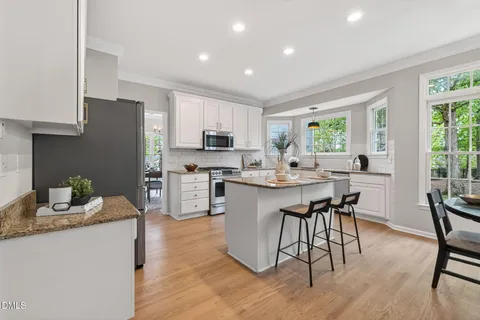 a kitchen with stainless steel appliances granite countertop a refrigerator and a stove top oven