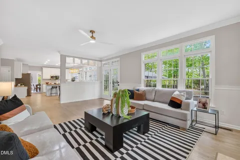 an empty room with windows and chandelier fan