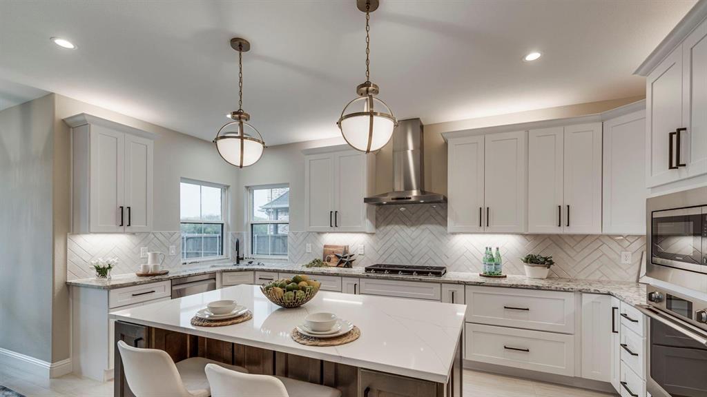 129 Old Bridge Road Waxahachie, TX 75165 - Photo 3 of 8 Kitchen featuring appliances with stainless steel finishes, a center island, light stone countertops, wall chimney exhaust hood, and recessed lighting