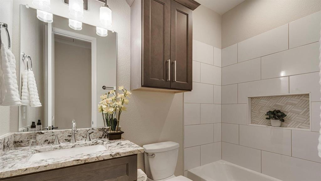 129 Old Bridge Road Waxahachie, TX 75165 - Photo 6 of 8 Bathroom with a textured wall, vanity, and bathing tub / shower combination