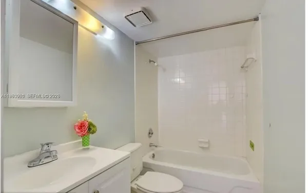 a bathroom with a sink vanity mirror and toilet