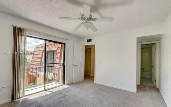 a view of a room with a ceiling fan and window