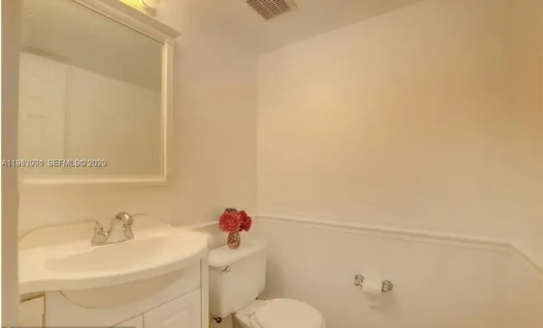 a bathroom with a sink mirror vanity and toilet