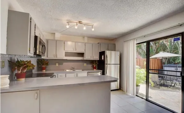 a kitchen with stainless steel appliances a sink a refrigerator a stove a cabinets and a counter top space