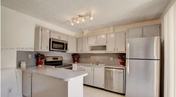 a kitchen with stainless steel appliances a refrigerator sink and microwave