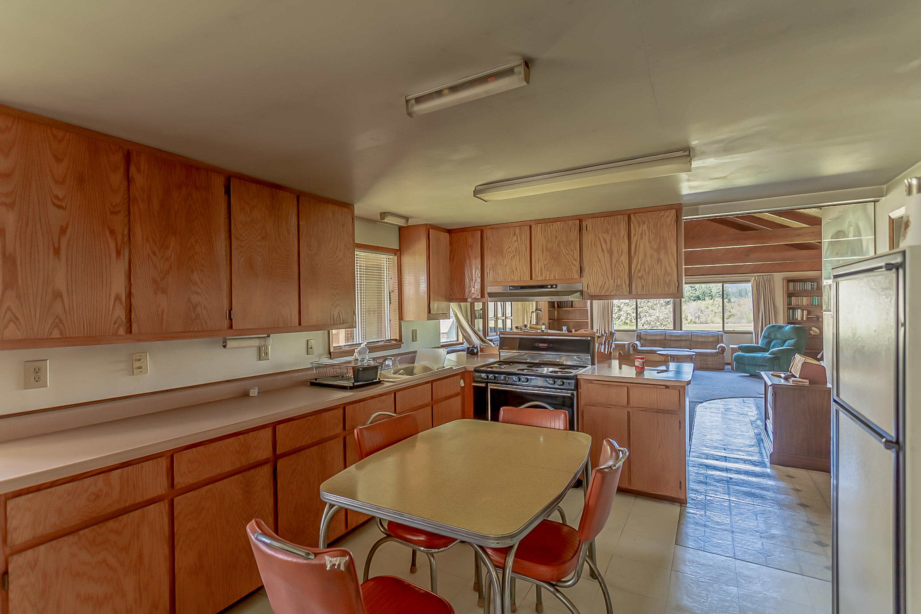 1040 Mullane Trail Big Bar, CA 96010 - Photo 16 of 49 a kitchen with stainless steel appliances granite countertop a stove a sink dishwasher a dining table and chairs with wooden floor