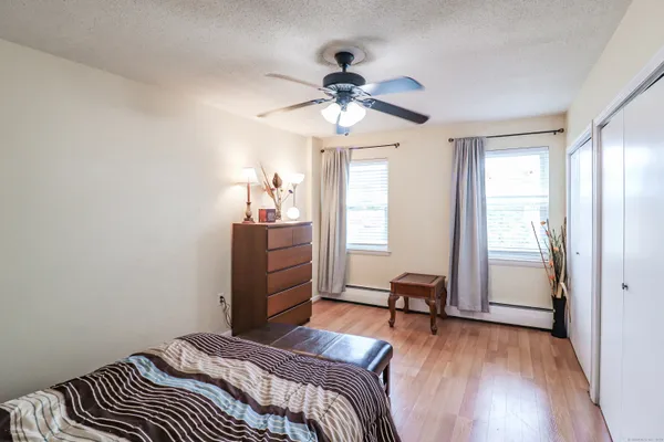 a bedroom with a bed and wooden floor