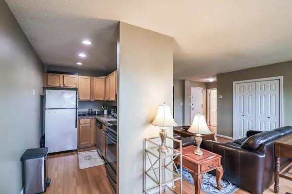 a kitchen with a refrigerator a stove and a dining table with wooden floor
