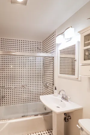 a bathroom with a sink a mirror and a shower