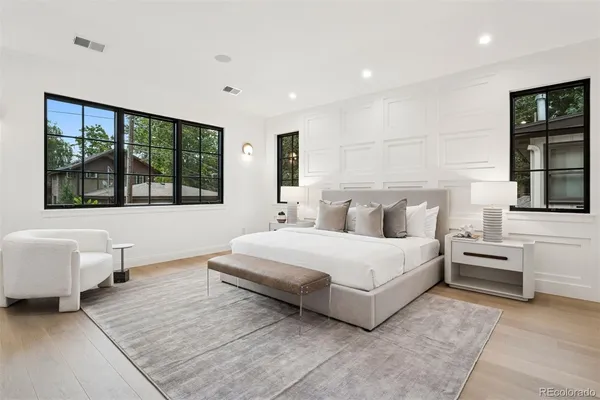 a bathroom with a double vanity sink a toilet and a large mirror