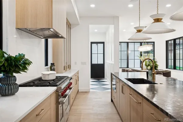 a kitchen with stainless steel appliances granite countertop a sink a stove and a wooden floors