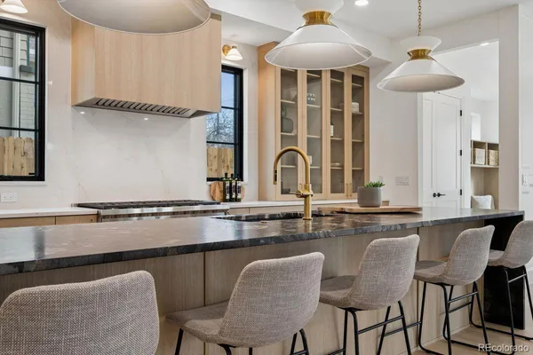 a kitchen with stainless steel appliances granite countertop a table chairs in it and wooden floors