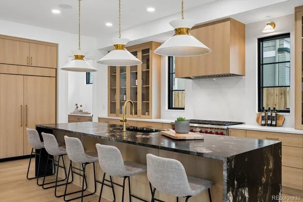 a kitchen with granite countertop a sink a stove a dining table and chairs