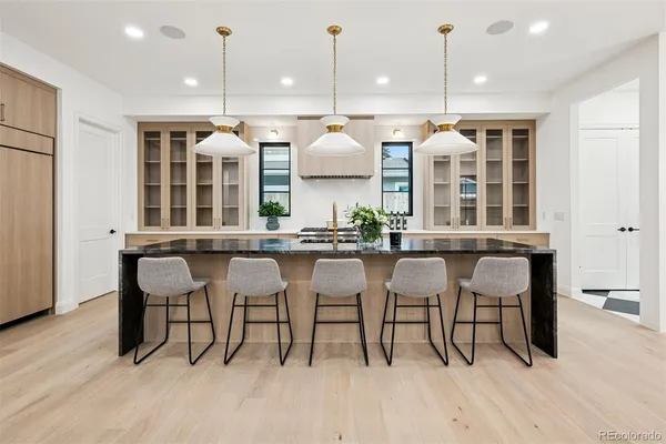 a room with stainless steel appliances kitchen island a table and chairs