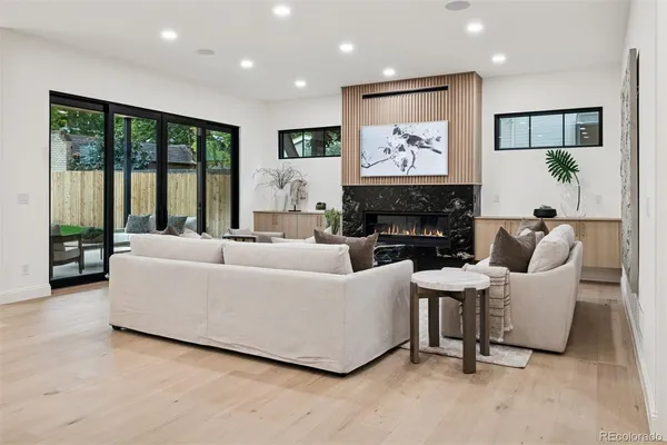 a living room with furniture a large window and a fireplace