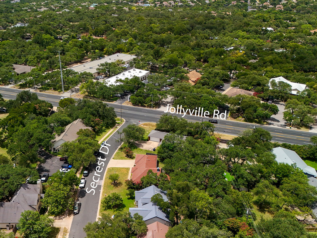 5842 Secrest Drive Austin, TX 78759 - Photo 24 of 40 An aerial perspective reveals a tree-filled neighborhood with established homes bordering a busy thoroughfare.