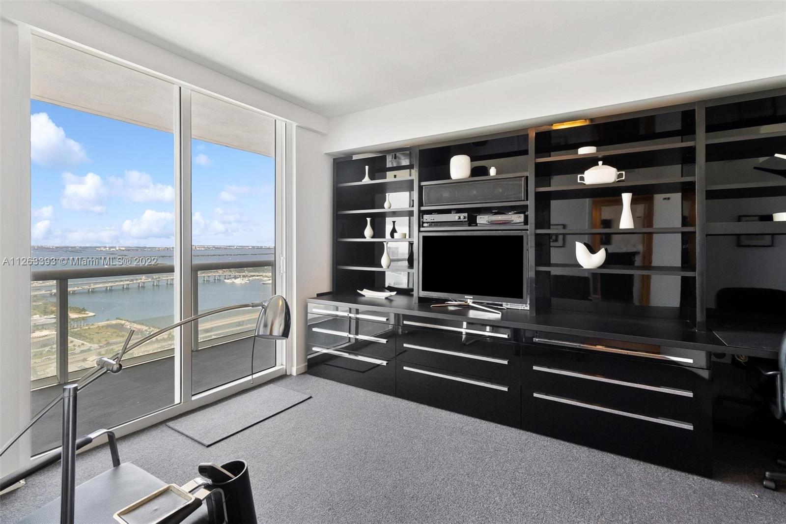 50 Biscayne Boulevard, Unit 4802 Miami, FL 33132 - Photo 13 of 33 a room with furniture and a flat screen tv