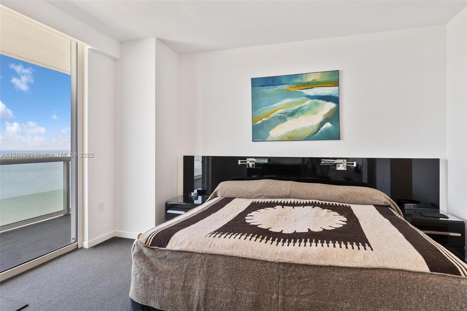 50 Biscayne Boulevard, Unit 4802 Miami, FL 33132 - Photo 17 of 33 a bedroom with a bed and painting on the wall