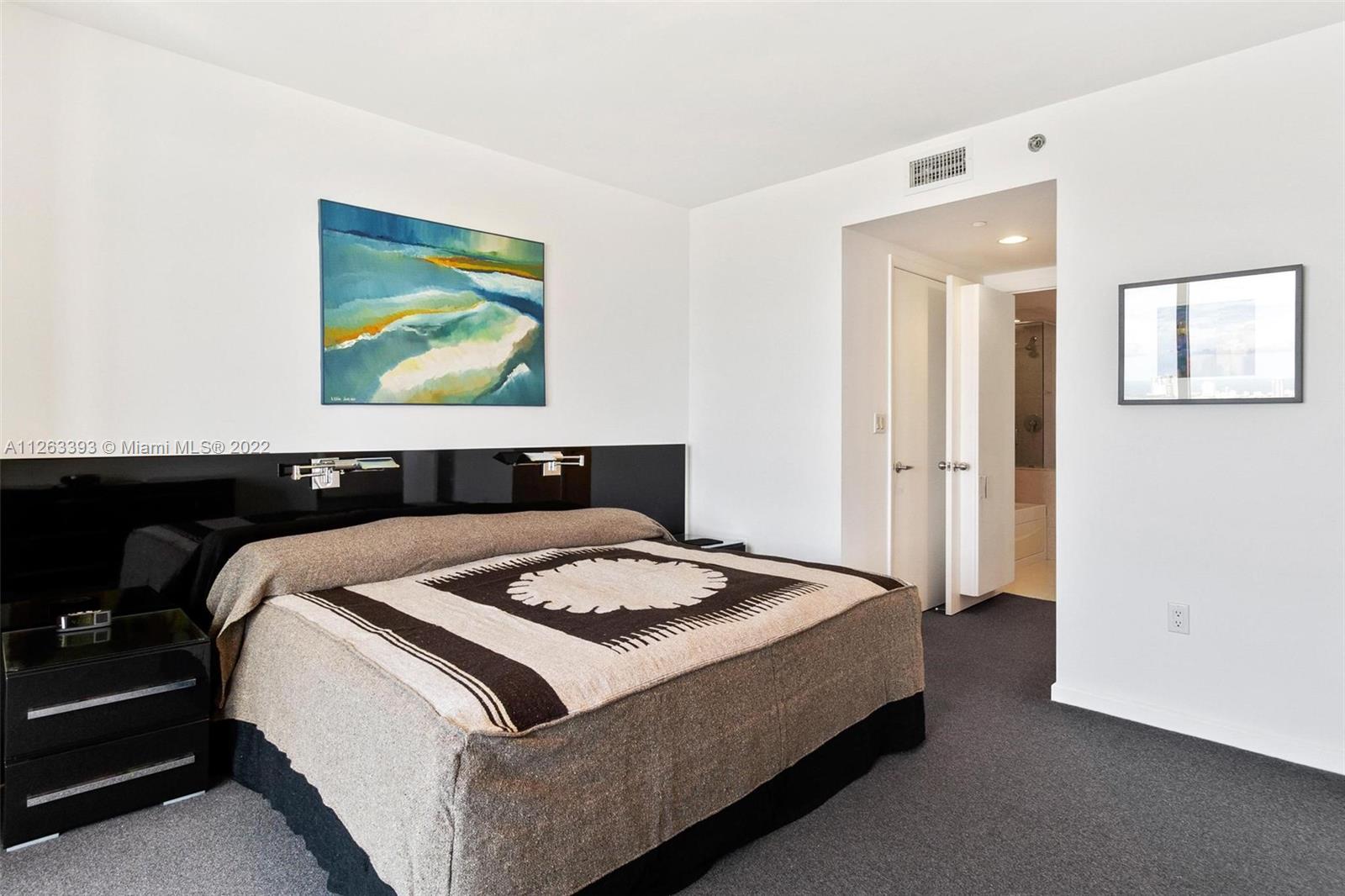 50 Biscayne Boulevard, Unit 4802 Miami, FL 33132 - Photo 18 of 33 a bedroom with bed and cupboard