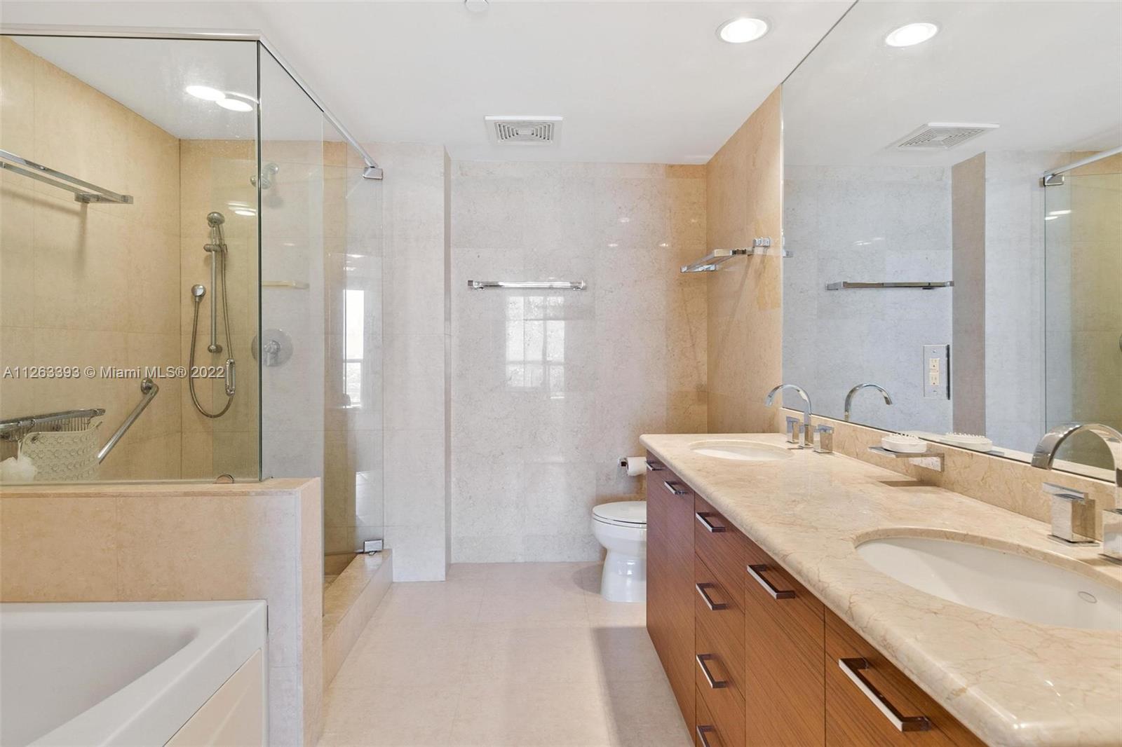 50 Biscayne Boulevard, Unit 4802 Miami, FL 33132 - Photo 19 of 33 a bathroom with a granite countertop sink mirror bathtub and shower