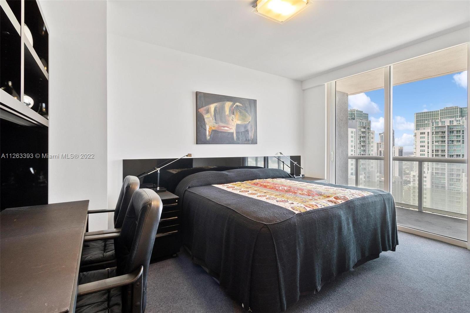 50 Biscayne Boulevard, Unit 4802 Miami, FL 33132 - Photo 21 of 33 a bedroom with a bed chair and a window