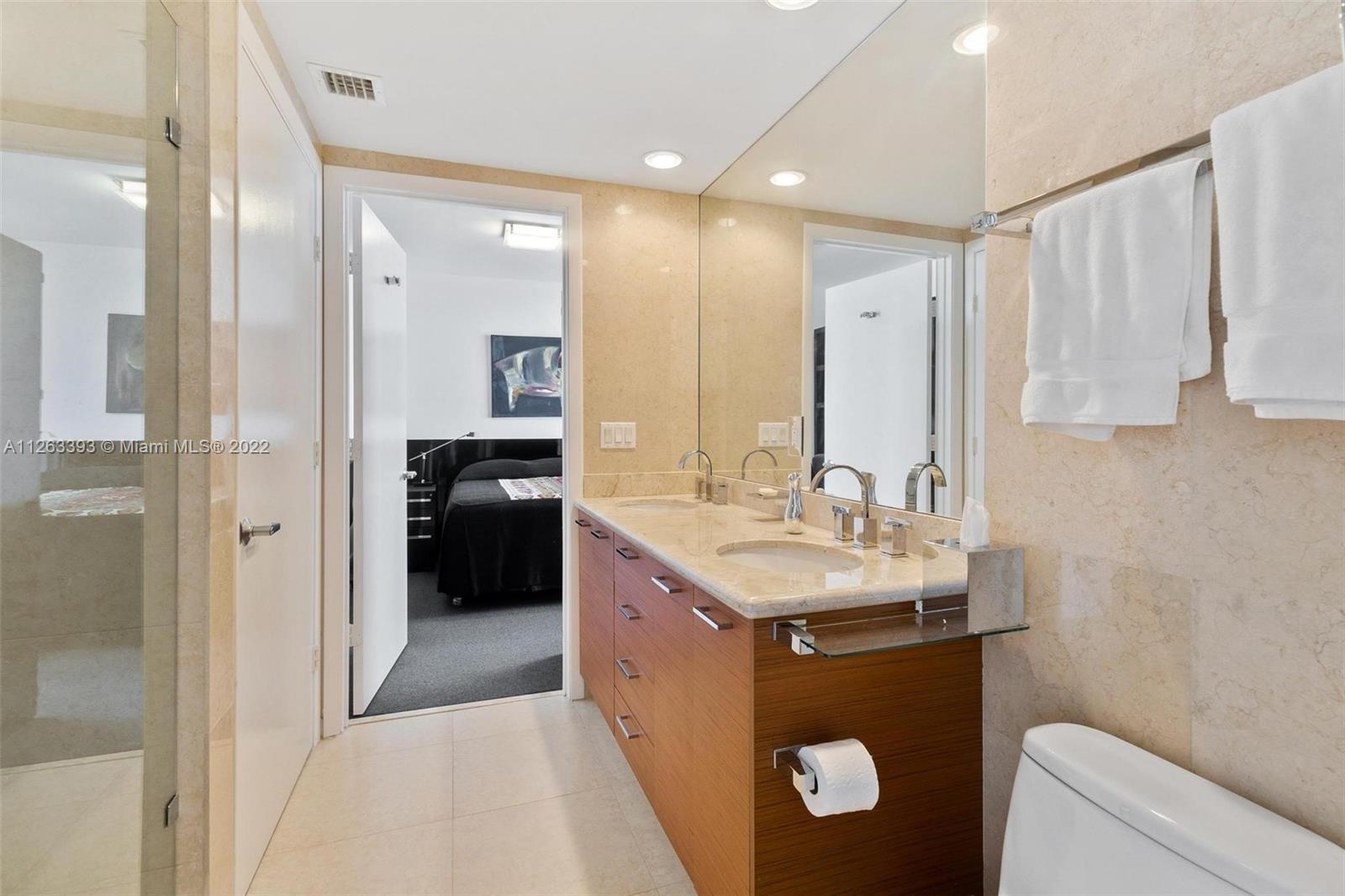 50 Biscayne Boulevard, Unit 4802 Miami, FL 33132 - Photo 26 of 33 a en suite bathroom with a sink double vanity and a mirror
