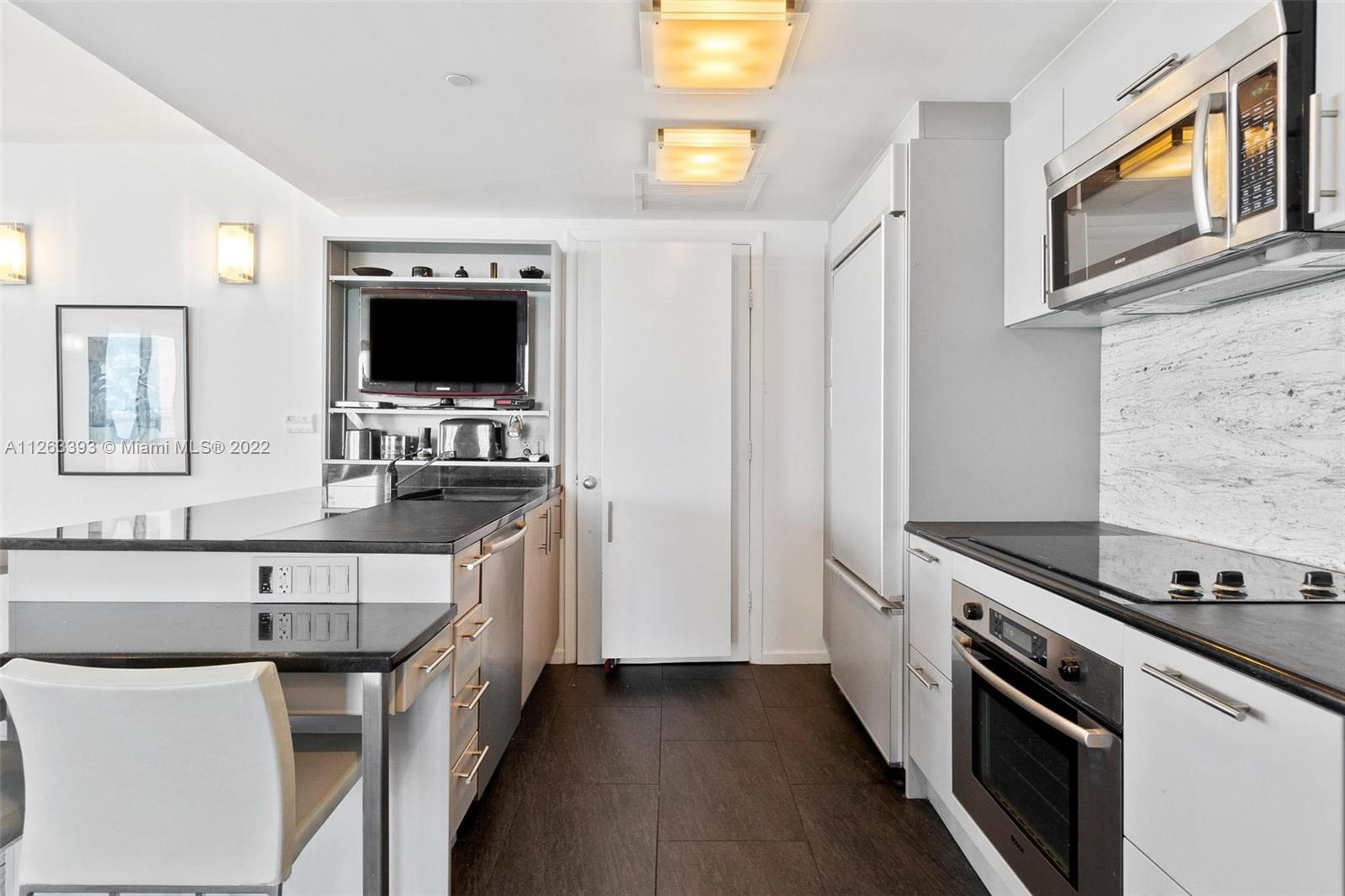 50 Biscayne Boulevard, Unit 4802 Miami, FL 33132 - Photo 8 of 33 a kitchen with stainless steel appliances a stove a sink and a microwave