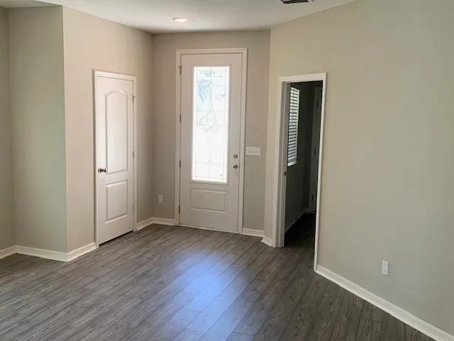 an empty room with wooden floor and a window