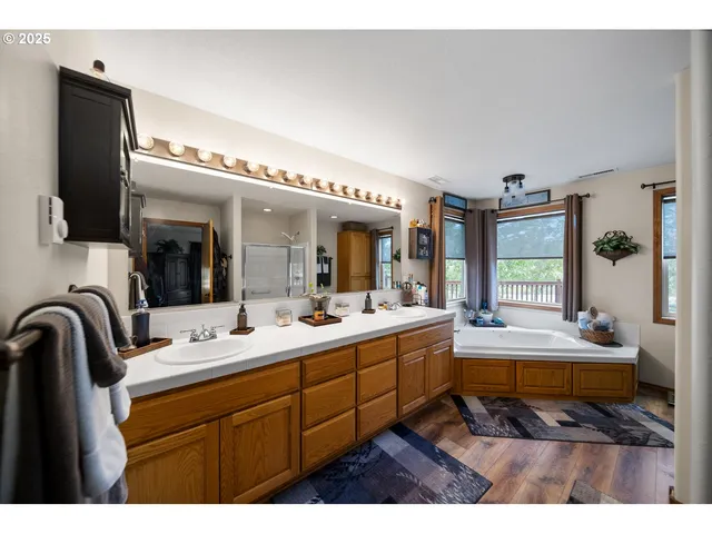 a en suite bathroom with a double vanity sink a mirror and a bathtub